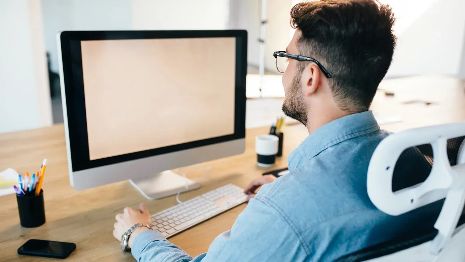 a man sitting at a desk using a computer